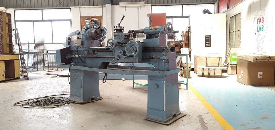 Máquina pesada sobre pies niveladores en una nave de producción